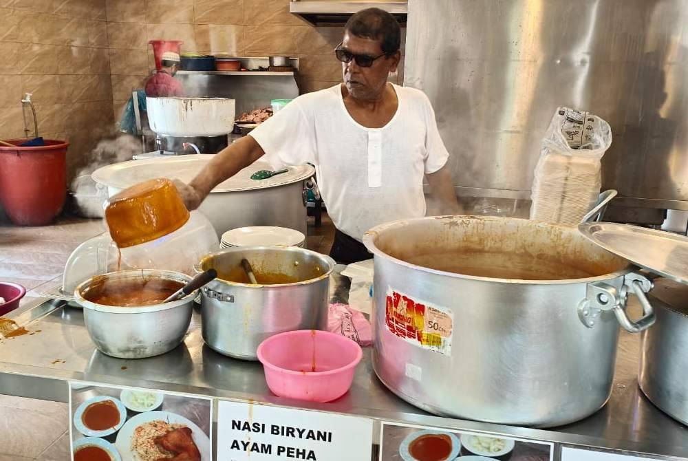Kamaruddin sedang membuat persiapan untuk jualan makanan di kedai makan miliknya di Kuantan pada Ahad.