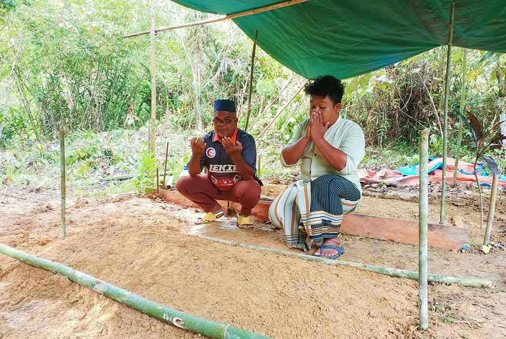 Zulkefli bersama Hadu menziarahi pusara Nuraina Humaira yang selamat dikebumikan di Tanah Perkuburan Orang Islam Kampung Bersah pada Isnin.