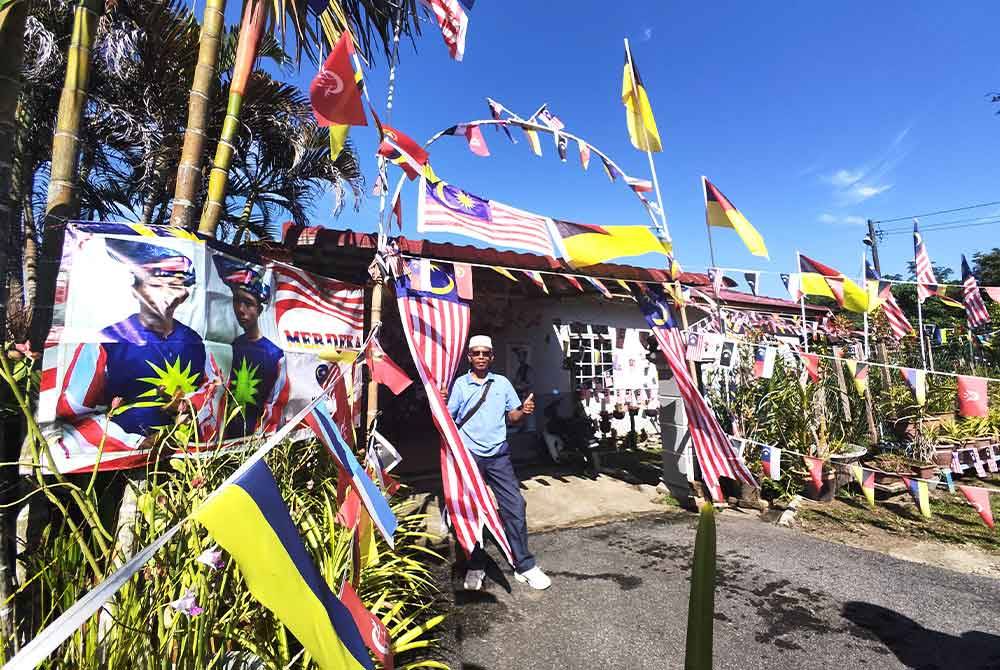 Rumah Hamzah merah dengan Jalur Gemilang dan bendera negeri lain.