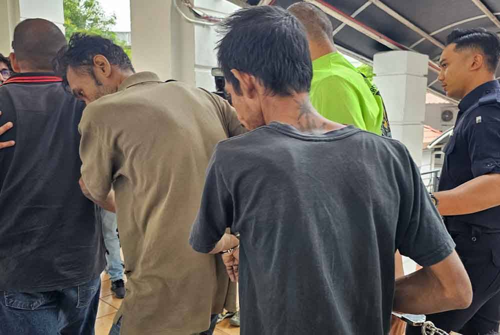 Muhamat Faizal (belakang) dan Mohd Ismail (tengah) dibawa ke lokap selepas dijatuhi hukuman penjara empat tahun di Mahkamah Sesyen Ipoh pada Selasa.