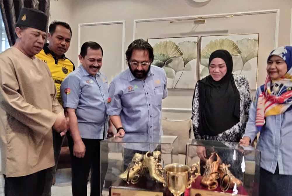 Subahan (tiga, kanan) melihat piala dan kasut emas milik Allahyarham Hashim ketika lawatan ke rumah Allahyarham pada Selasa.