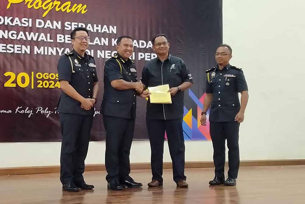 Shamsul Nizam (dua dari kiri) menyampaikan Arahan Pengawal Bekalan kepada wakil pengusaha stesen minyak sempena Program Advokasi dan Serahan Arahan Pengawal Bekalan Kepada Pengusaha Stesen Minyak di Negeri Perak di Dewan Utama KPTM Ipoh di sini pada Selasa.