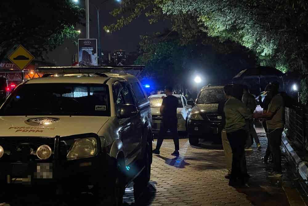 Anggota polis memeriksa lokasi kejadian tembak di Subang Jaya pada Selasa.