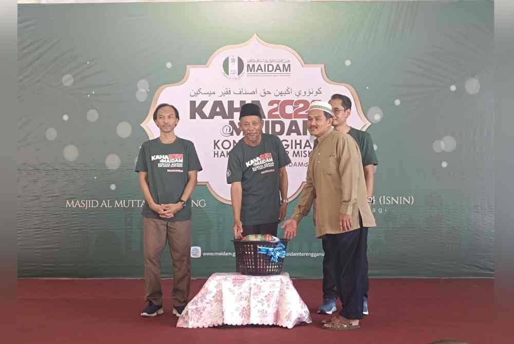 Shaikh Harun (dua dari kiri) memberi sumbangan berupa bakul barangan keperluan kepada penerima pada Isnin.