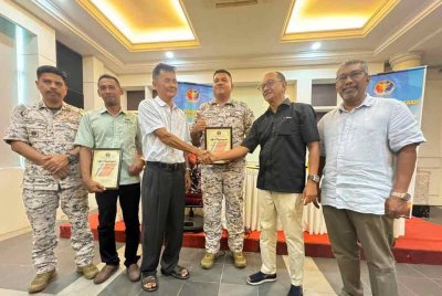 Razali (tengah) menyaksikan How Chai (tiga dari kiri) dan Mahadi (dua dari kanan) berjabat tangan menandakan masalah yang membelenggu kedua-dua pihak sejak lebih 20 tahun lalu telah selesai.