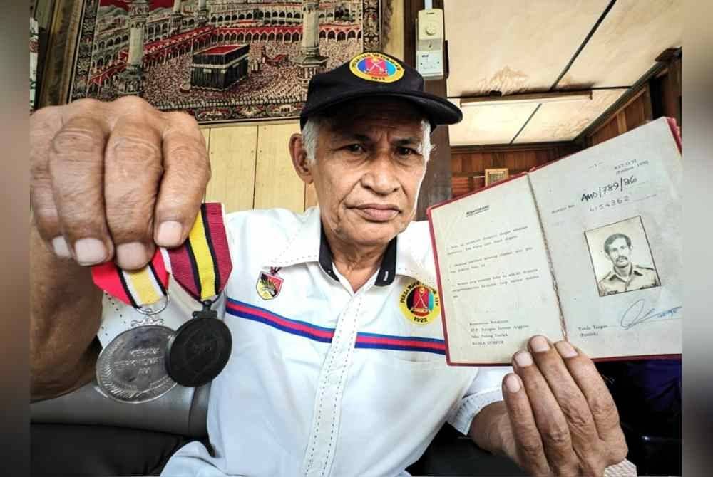 Abdul Jalil menunjukkan pingat dan buku rekod keanggotannya.