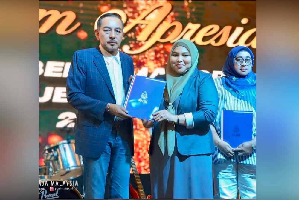 Adila Sharinni (tengah) menerima sijil penghargaan daripada Muhamad Zaki (kiri).