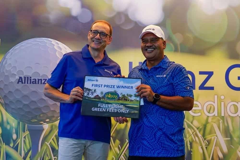 Giulio (kiri) menyampaikan hadiah kepada Mahathir yang meraih Juara bagi kategori individu dalam Kejohanan Golf itu.