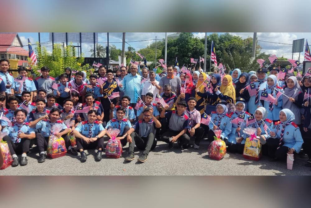 Mahfuz (tengah) bergambar dengan peserta pada Program Kibar Jalur Gemilang di Tapak Parkir An-Nur, Pokok Sena pada Khamis.