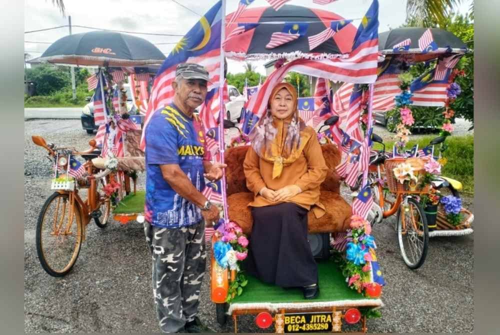 Yazid dan isterinya, Rahah Ahmad, 69, bersama beca miliknya yang dihiasi dengan Jalur Gemilang.
