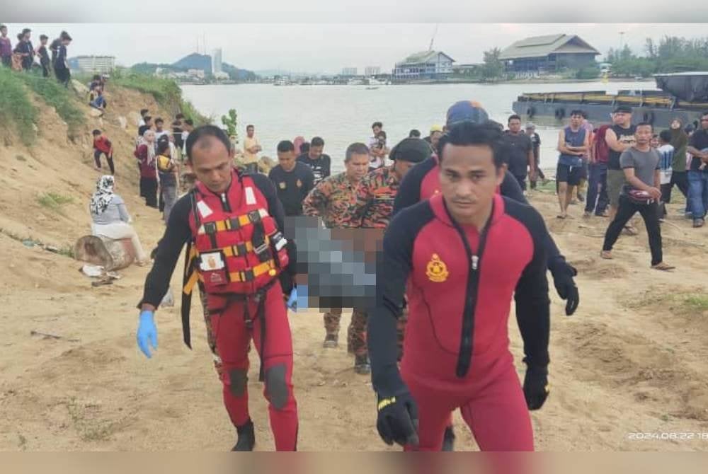 Pasukan penyelamat mengangkat mayat mangsa yang lemas di Sungai Terengganu di Kampung Batin, Seberang Takir pada Khamis. Foto JBPM Terengganu