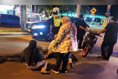 Mohd Ridzuan terbaring di jalan raya selepas terjatuh dari motosikal ditunggangnya. Foto ihsan pembaca