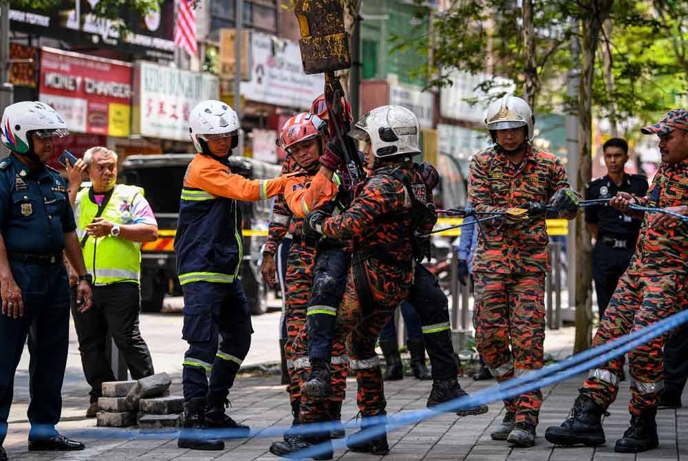 Pasukan penyelamat terpaksa menggunakan jentera kren DBKL dalam usaha mencari seorang wanita warga India yang terjatuh dalam tanah jerlus di Jalan Masjid India. Foto Bernama
