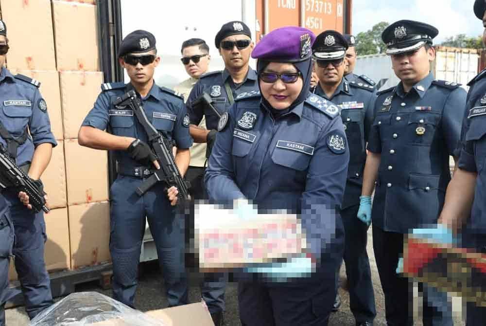 Anis Rizana (tiga,kanan) menunjukkan antara rokok kretek yang dirampas pihaknya ketika sidang akhbar di Wisma Kastam, Pulau Indah pada Jumaat.