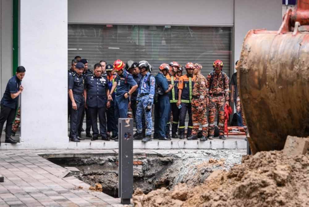 Ketua Polis Kuala Lumpur Datuk Rusdi Mohd Isa (tiga, kiri) hadir ke lokasi seorang wanita warganegara India yang dipercayai terjatuh kira-kira 10 meter lalu tertimbus tanah mendap di Masjid India, Kuala Lumpur kira-kira 8 pagi tadi.
