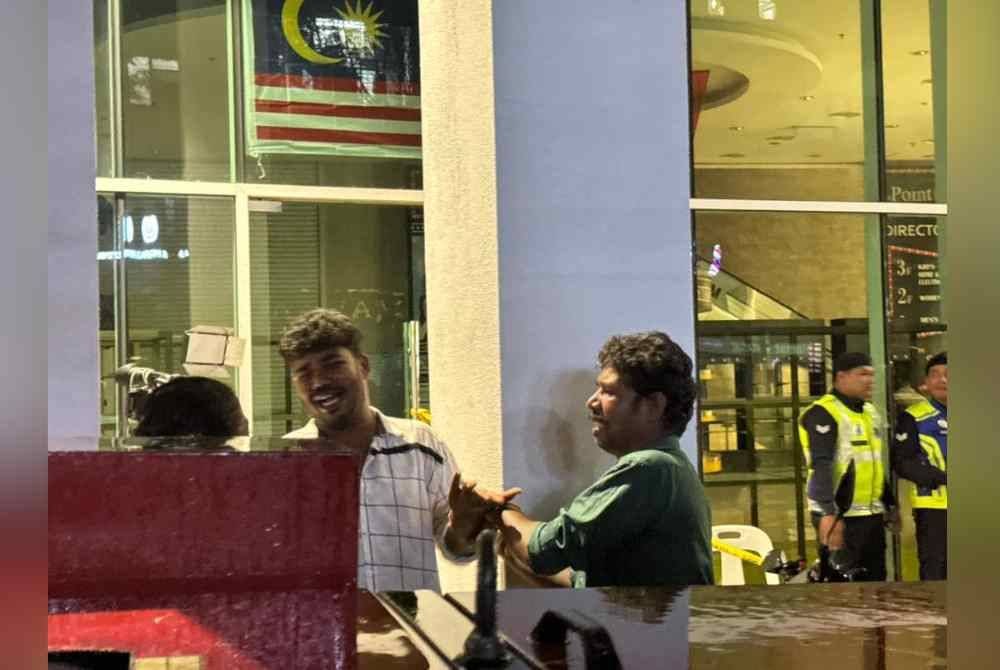 Surya (tengah) ditenangkan oleh bapanya dan keluarga yang berada di lokasi kejadian di Jalan Masjid India, di sini, pada Jumaat.