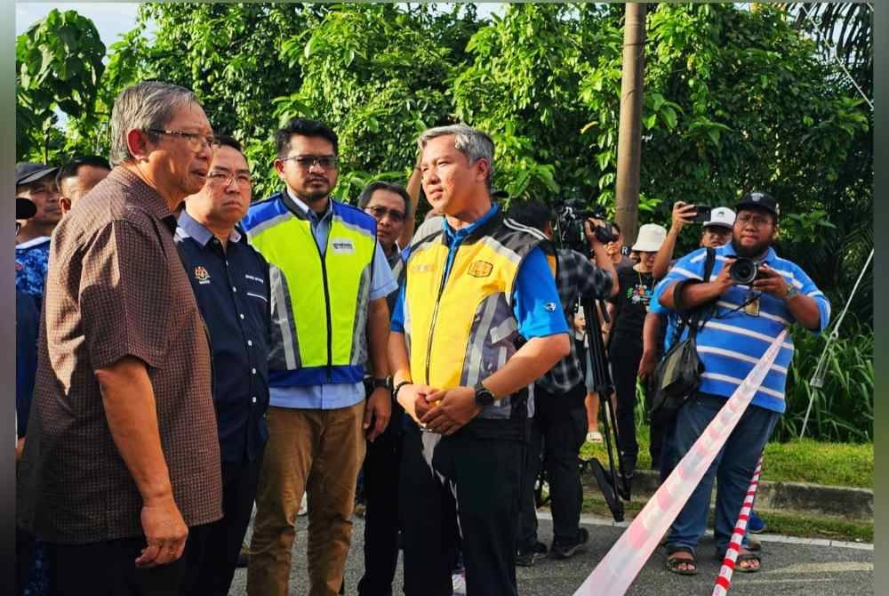 Mohammad Nizar (kiri) bersama Lih Kang (dua dari kiri) ketika meninjau keadaan runtuhan Jambatan Lama Sungai Slim di Jalan Slim River-Behrang Ulu pada Sabtu.