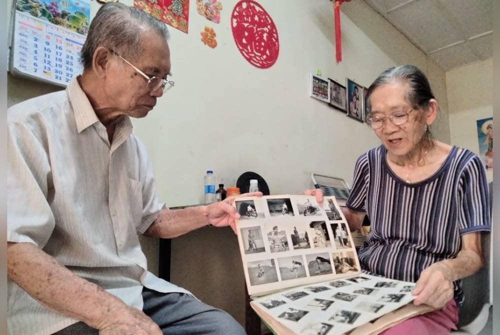 Kee Liang (kiri) bersama Siew Ho menunjukkan gambar kenangan ketika bertugas sebagai tentera.
