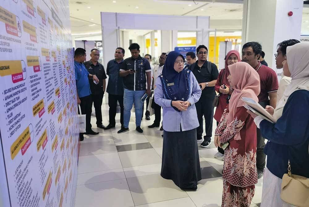 Farihah (tengah) berbual bersama pengunjung Karnival Kerjaya MyFutureJobs 'Tiada Yang Terpinggir' 2024 di KTCC Mall, Kuala Terengganu pada Ahad.