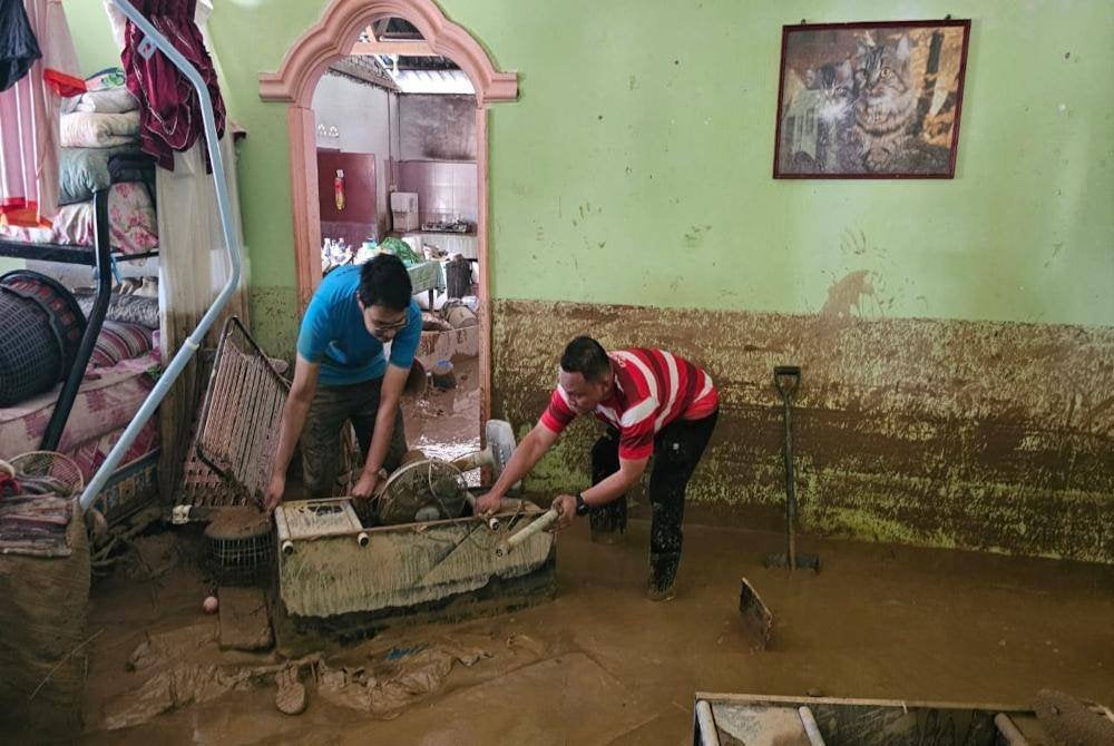 Penduduk mengangkat perabot-perabot rumah mereka yang musnah dalam insiden kepala air di Slim Village pada Ahad.