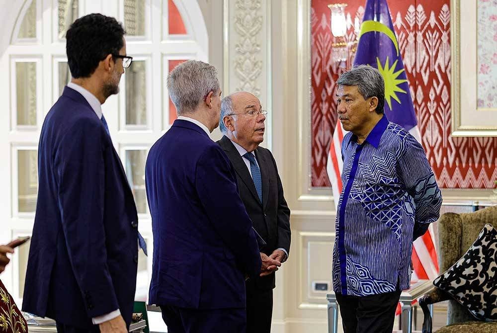 Mohamad (kanan) bersama Vieira (tiga, kiri) ketika menunggu ketibaan Perdana Menteri, Datuk Seri Anwar Ibrahim di Kompleks Seri Perdana pada Ahad. Foto Bernama