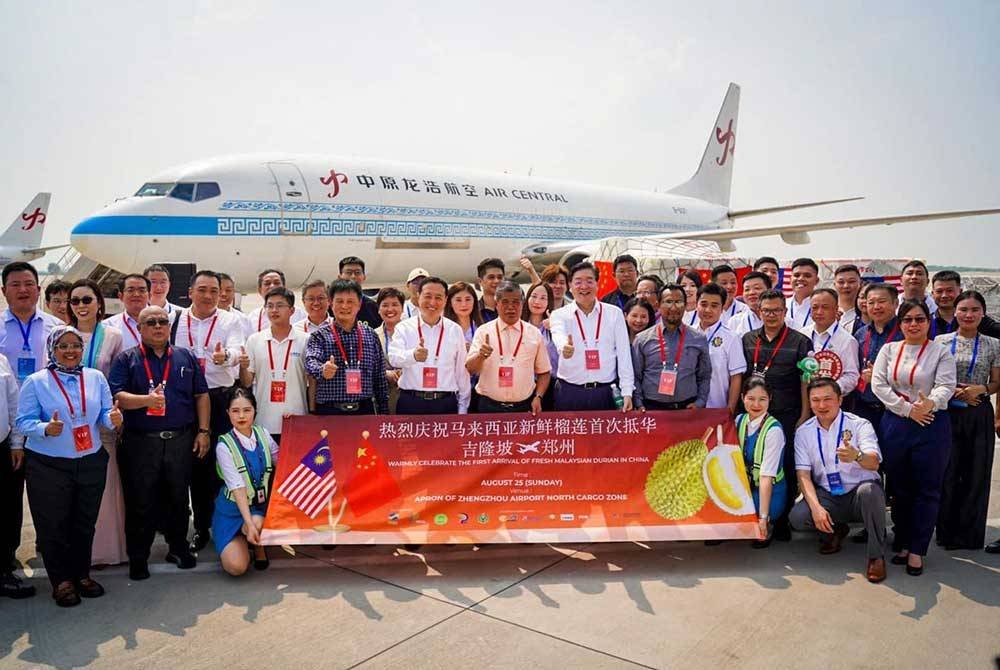 Mohamad (tengah) menyempurnakan majlis penerimaan durian segar melalui udara yang pertama ke China bersama Timbalan Gabenor Eksekutif Wilayah Henan, Sun Shougang dan Pengurus Besar Zhongyu Aviation Group, Liu Jianmin di Lapangan Terbang Kargo Zhengzhou, China pada Ahad.