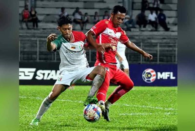 Perebutan bola di antara pemain Pertahanan Kuching City FC, Jimmy Raymond dengan pemain Kelantan Darul Naim pada saingan Liga Super di Stadium Negeri pada Isnin.