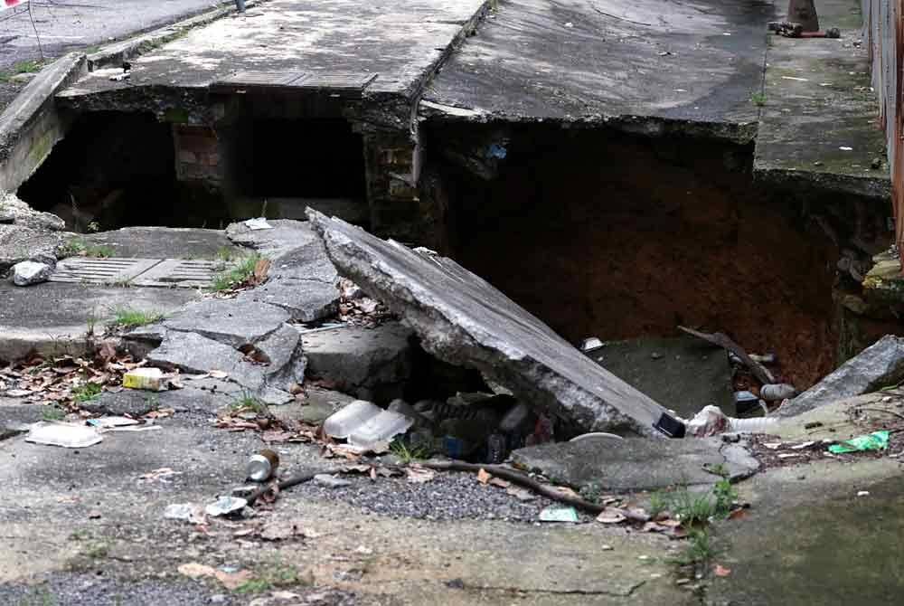 Keadaan longkang runtuh sehingga mengakibatkan lubang besar berlaku di Jalan Pantai Permai, Kampung Kerinchi dalam kejadian yang berlaku semalam. Foto Bernama