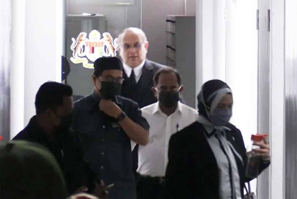 Mohamad Zahari (dua dari kanan) bersama isteri (kanan) keluar dari pekarangan mahkamah, pada Rabu.