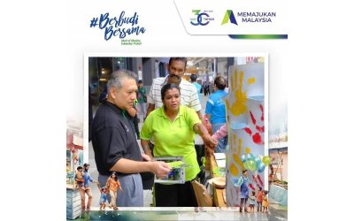 Amirul Feisal (kiri) mendengar penerangan daripada salah seorang wakil pempamer yang menyertai Program #BerbudiBersama di Medini Mall, Iskandar Puteri pada Sabtu.