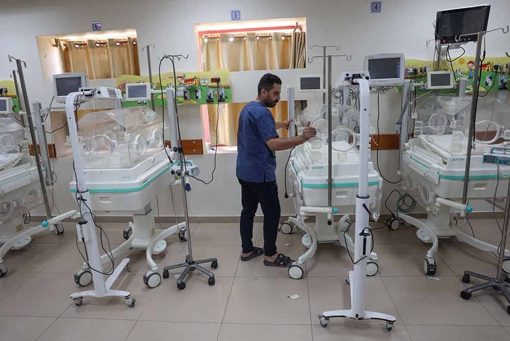 Kakitangan perubatan melakukan persediaan untuk memindahkan bayi pramatang.