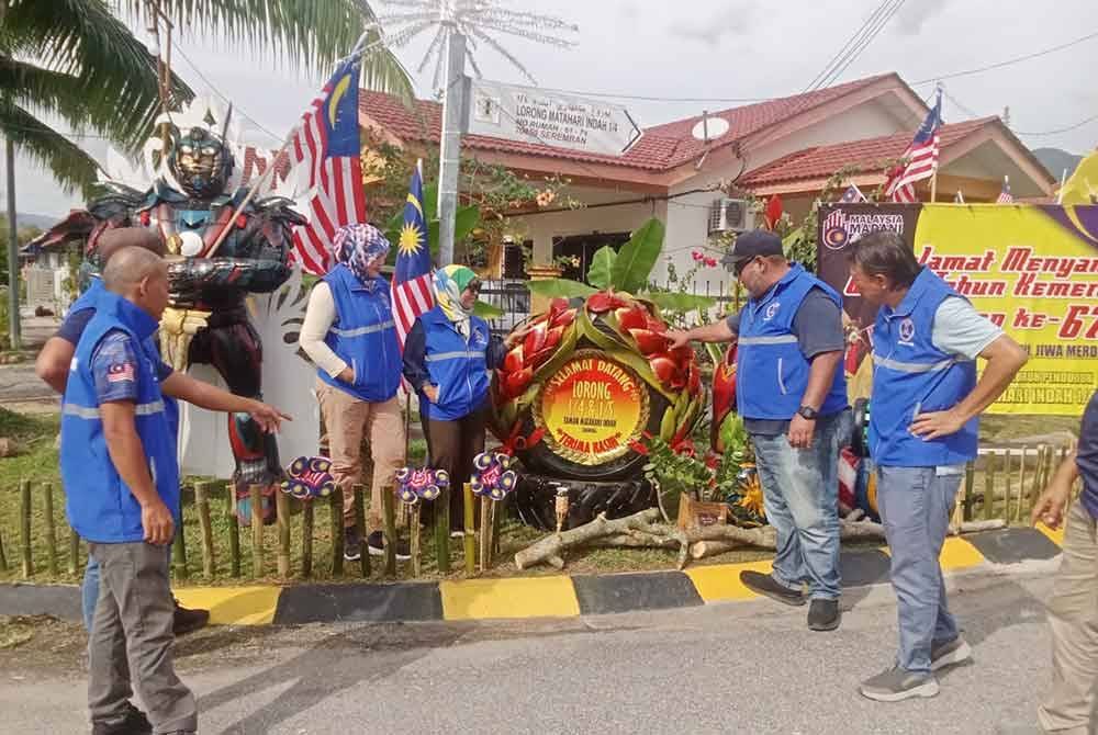Mohd Faizul (dua kanan) ketika meninjau hiasan kemerdekaan yang dibuat penduduk.