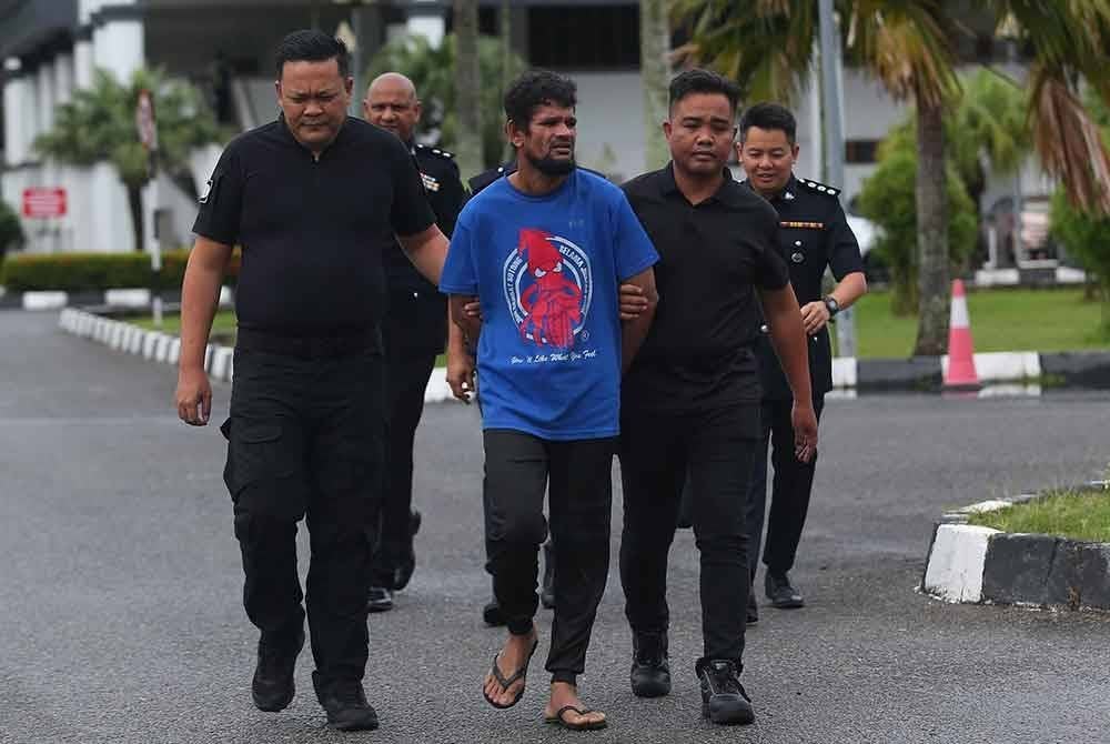 Abdu Gapur (tengah) diiringi anggota polis di pekarangan Mahkamah Majistret Alor Setar pada Khamis.
