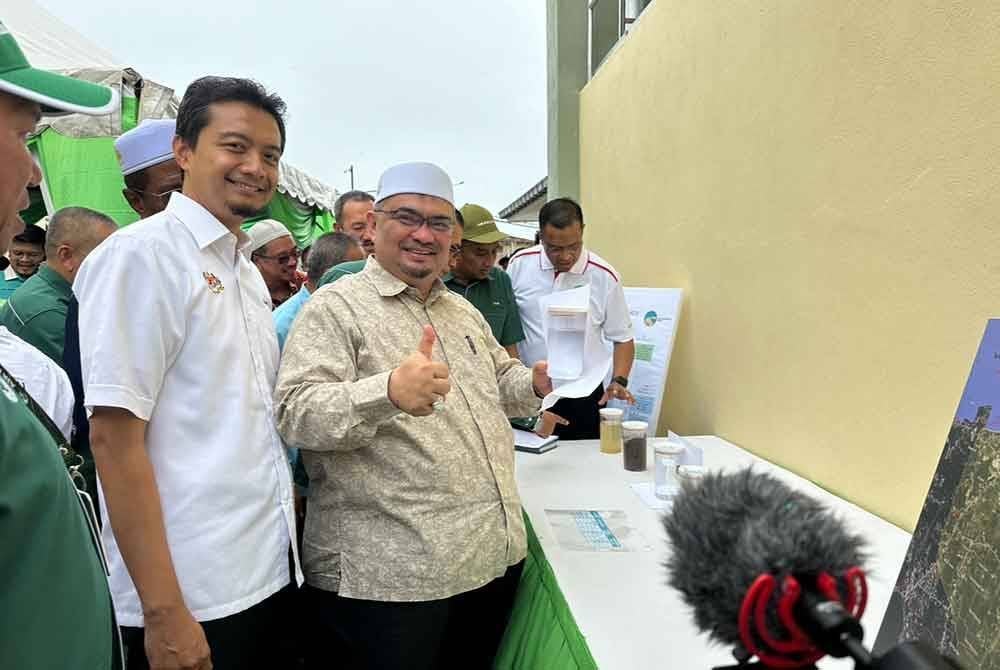 Mohamed Fadzli (dua dari kiri) menunjukkan air terawat dari LRA Jelawat di Bachok.
