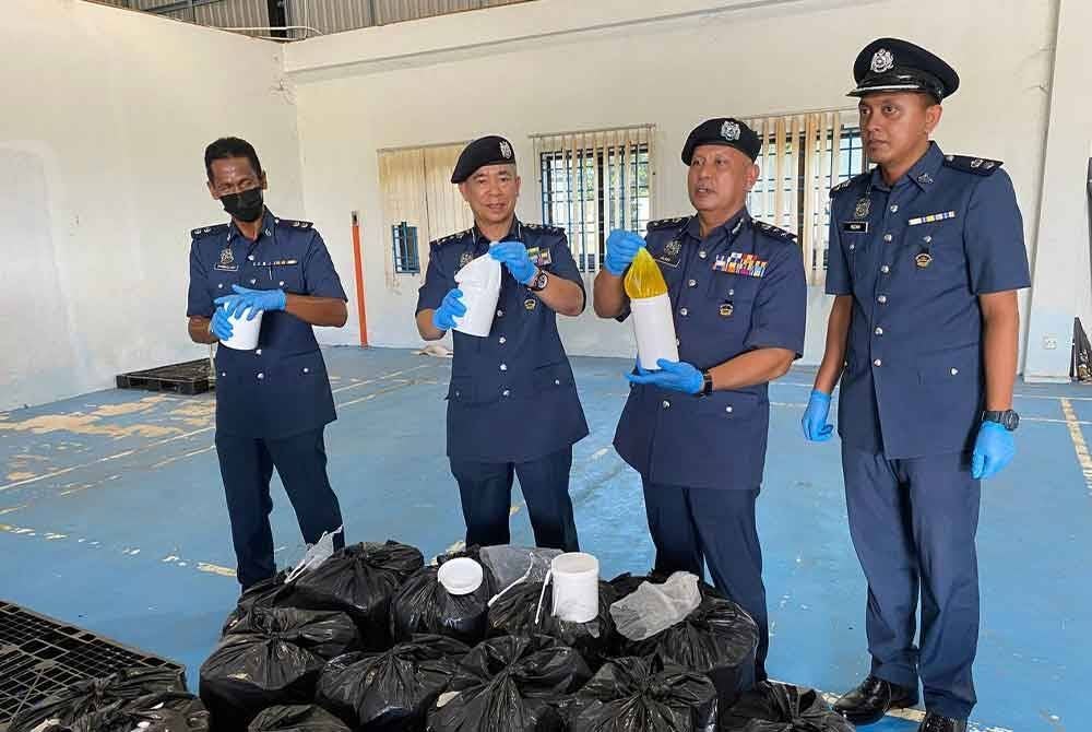 Wan Jamal Abdul Salam (dua, kiri) menunjukkan sebahagian daripada kosmetik yang dirampas.