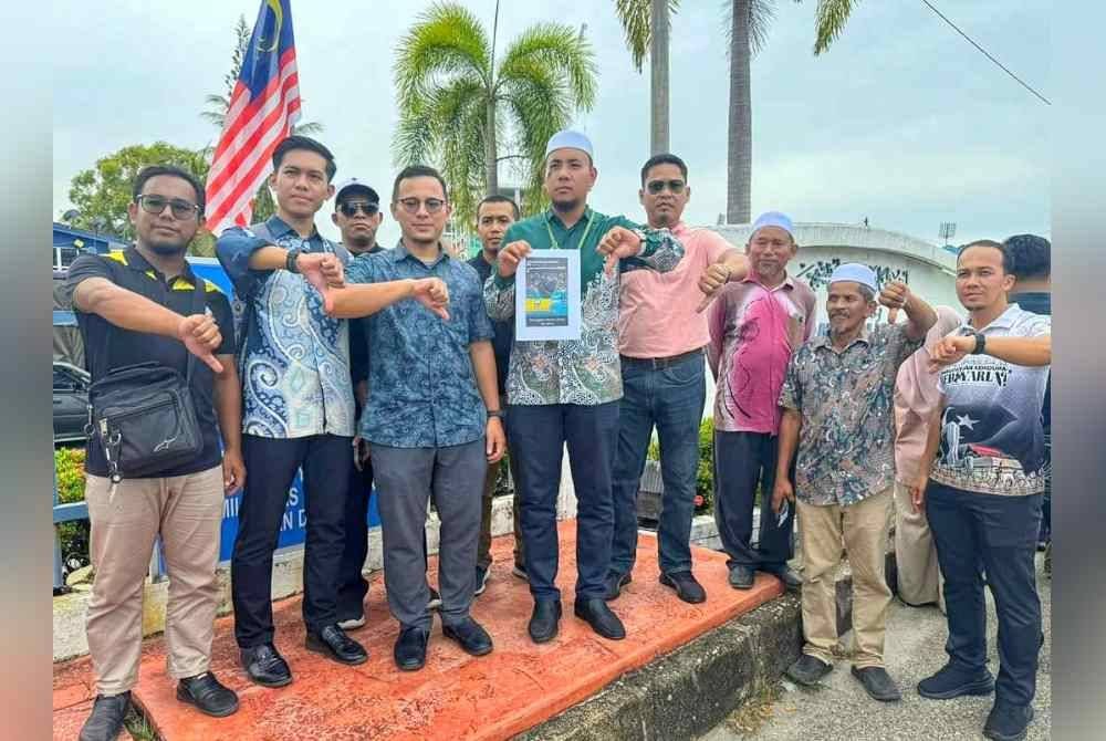 Muhammad Irsyad Syafiq (tengah) selepas membuat laporan polis di IPD Kuala Terengganu pada Khamis.