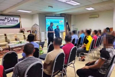 Mohd Nasir (berdiri, kiri) menyampaikan ucapan Program Pelepasan Orang Bebas Berlesen (OBB) Sempena Hari Kebangsaan 2024 Ihsan Madani 'Kepulangan Yang Dinanti' di PPA Machang pada Khamis.