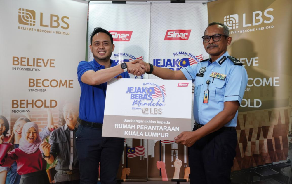 Amal (kiri) menyerahkan replika sumbangan untuk Rumah Perantaraan Kuala Lumpur kepada Aminon.