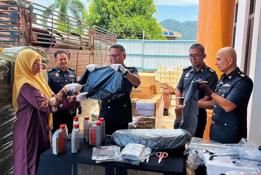 Jezlily ( dua dari kiri) bersama Ketua Pegawai Penguat kuasa KPDN Pahang, Muhamad Radzi Johari (dua dari kanan) membantu melupuskan barang rampasan yang dilupuskan pada Khamis.