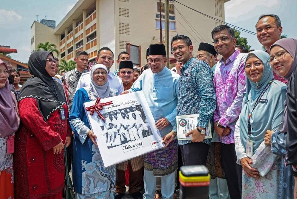 Anwar menerima cenderahati daripada Pengarah Kesihatan Negeri Pulau Pinang, Datuk Dr Fazilah Shaik Allaudin (tiga, kiri) ketika melakukan lawatan di Hospital Bukit Mertajam pada Jumaat. Foto Bernama