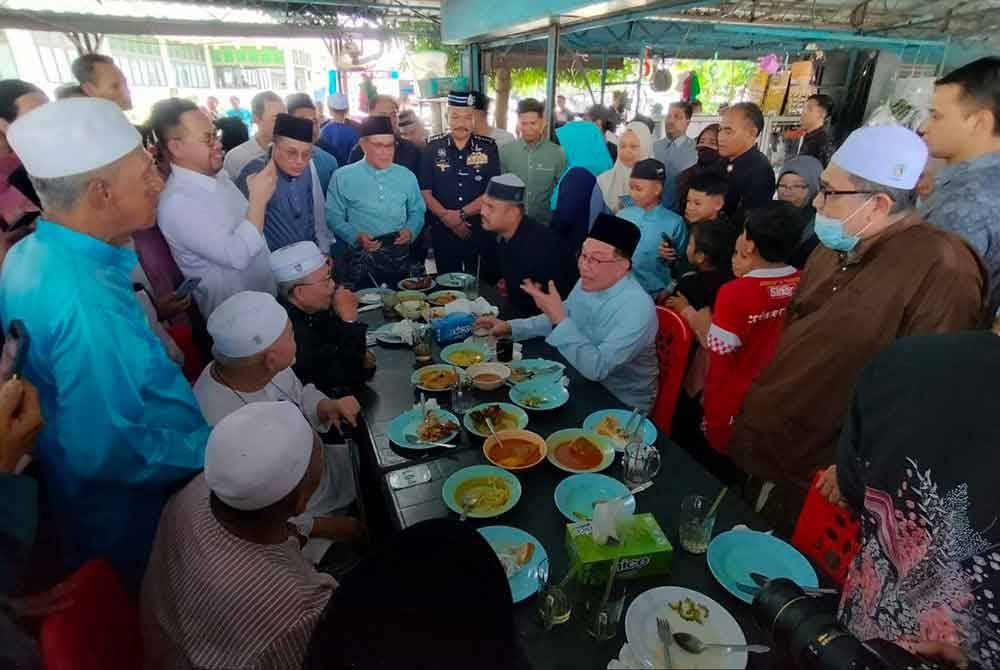 Anwar menikmati nasi kandar sebelum menunaikan solat Jumaat di Masjid Kubang Semang, pada Jumaat.