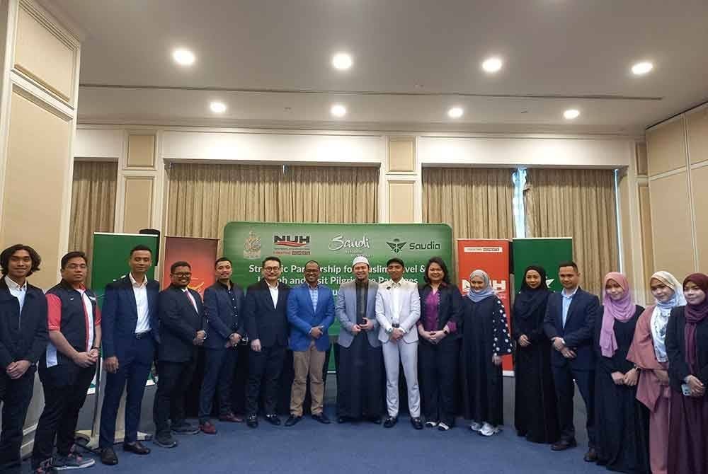 Abdul Halim Aliumar (lima kiri) bergambar bersama kakitangan Saudi Airlines (Saudia) pada Majlis Menandatangani Rakan Strategik Kembara Muslim dan Pakej Umrah Ziarah Dubai di sebuah hotel di Petaling Jaya pada Khamis.