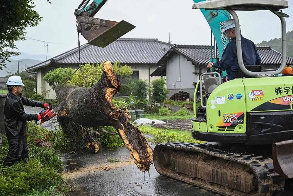 Kerja-kerja pembersihan pokok tumbang dilakukan susulan taufan Shanshan di Jepun. Foto AFP