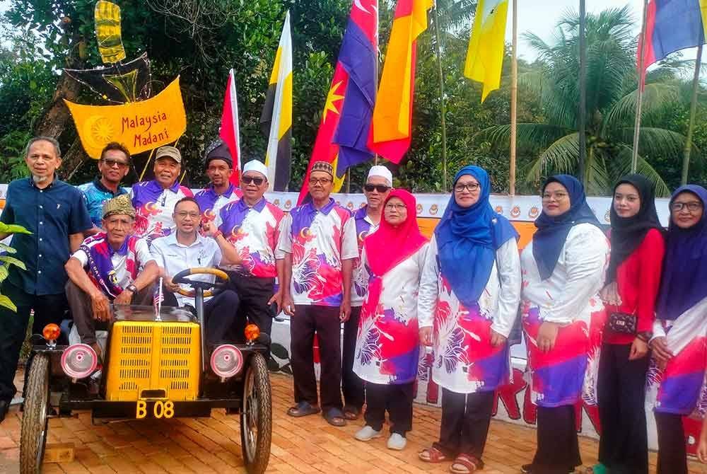 Ketua UMNO Bahagian Jerantut, Haris Salleh Hamzah (duduk, kanan) turut tertarik dengan replika kereta yang dihasilkan penduduk Blok 8.