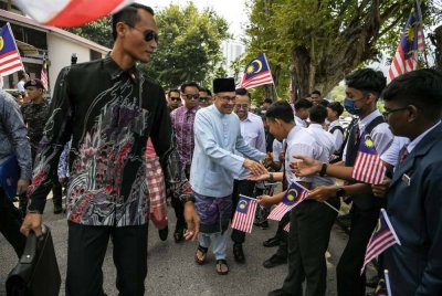 Anwar menyantuni para pelajar ketika hadir pada program Kunjungan di Sekolah Menengah Kebangsaan Tinggi Bukit Mertajam pada Jumaat. Foto Bernama