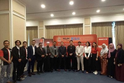 Abdul Halim Aliumar (lapan kiri) bergambar bersama kakitangan Emirates Airlines pada Majlis Menandatangani Rakan Strategik Kembara Muslim dan Pakej Umrah Ziarah Dubai di sebuah hotel di Petaling Jaya pada Khamis.