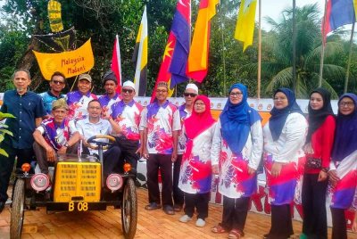 Ketua UMNO Bahagian Jerantut, Haris Salleh Hamzah (duduk, kanan) turut tertarik dengan replika kereta yang dihasilkan penduduk Blok 8.