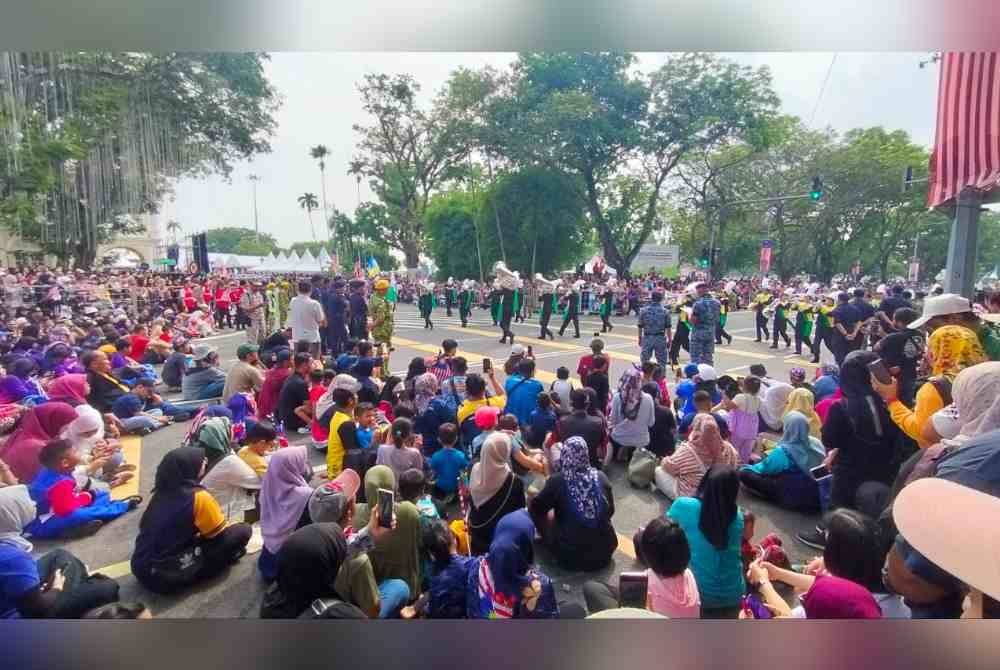 Orang ramai mengambil tempat untuk menyaksikan perbarisan dan perarakan sempena Hari Kebangsaan Ke-67 Peringkat Pulau Pinang yang diadakan di Padang Kota Lama pada Sabtu.