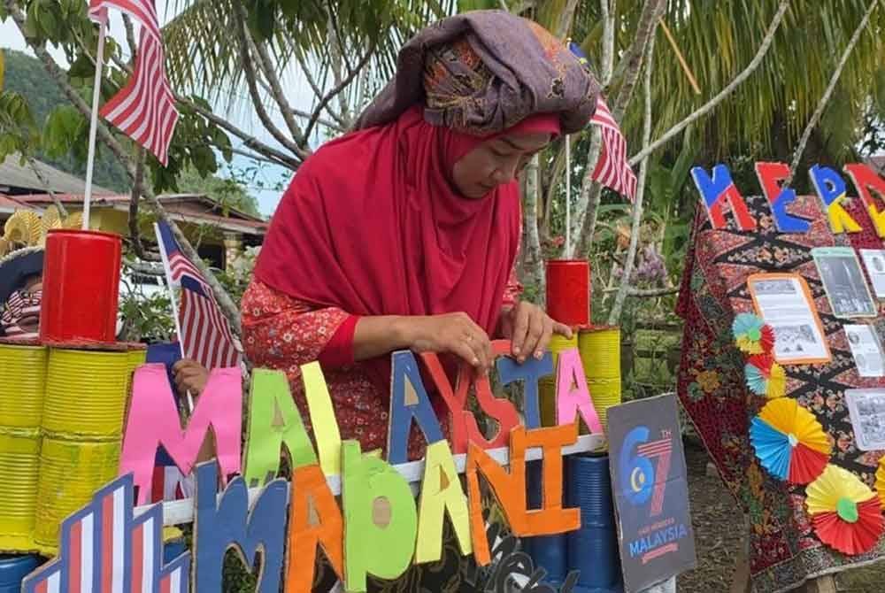 Masniza menggunakan kertas, tin dan kotak untuk menghasilkan replika serta hiasan sempena bulan kemerdekaan negara kali ke-67.