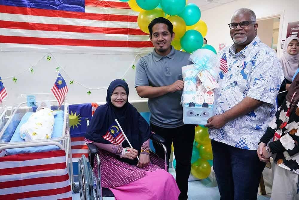 Timbalan Pengarah Kesihatan (Perubatan) JKWPKL dan Putrajaya, Dr Muhammad Yusuf Sibert (kanan) menyampaikan cenderahati kepada ⁠Adly Ukasha Abdul Malik dan isterinya, Iffatun Nisa Abdul Halim pada majlis Sambutan Bayi Merdeka Hospital Putrajaya pada Sabtu. FOTO: SINAR HARIAN / MOHD HALIM ABDUL WAHID